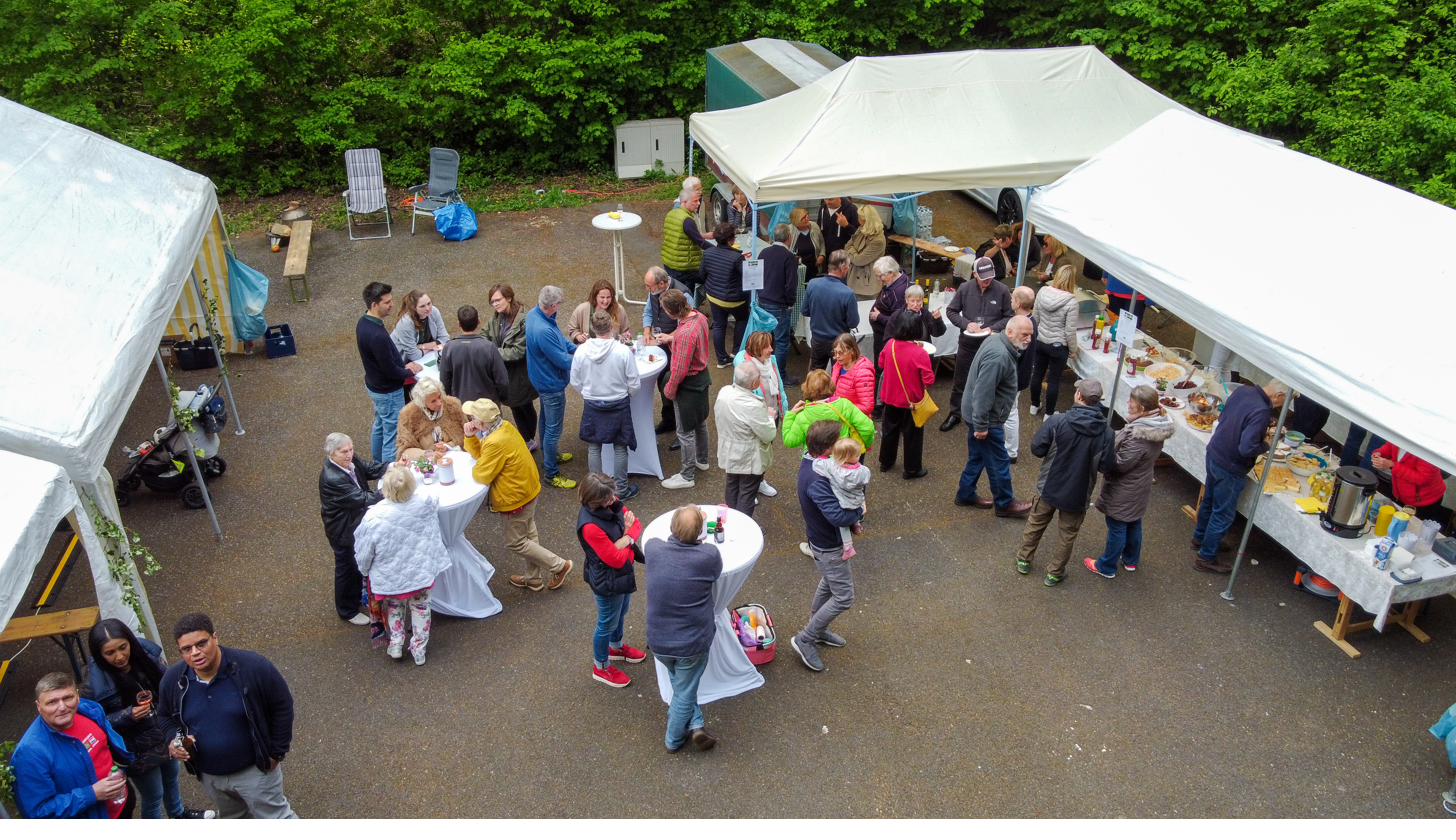 Maifest in Osenau aus der Vogelperspektive: Pavillons, Stehtische und feiernde Nachbarschaft.