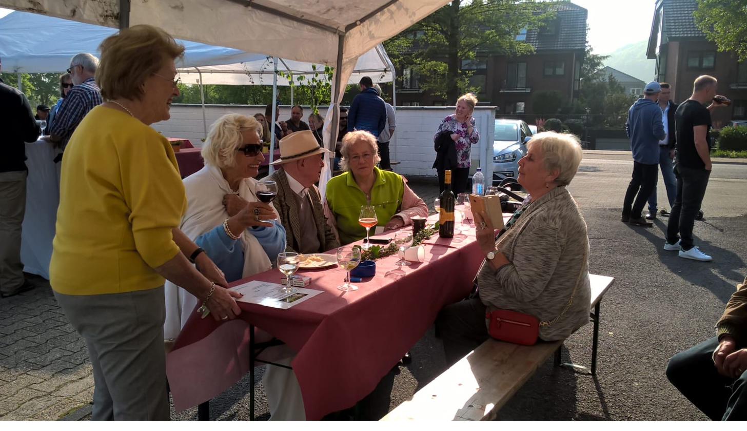 Geselliger Tisch mit Wein und Gespräch beim Maifest.